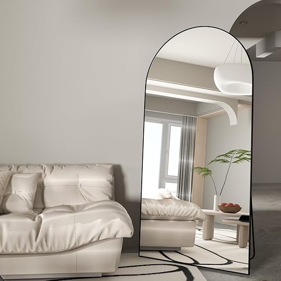Large arched floor mirror in a modern bedroom setting.